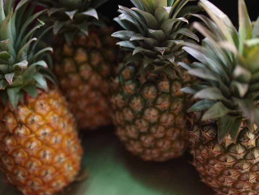 Close-up view of multiple pineapples with varying ripeness stages